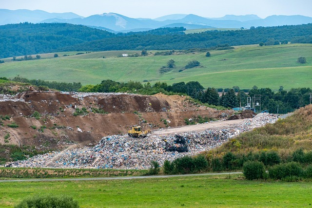 Excavated dump area at a landfill facility with heavy equipment driving on compacted waste, managing material placement and site operations under active landfill conditions.