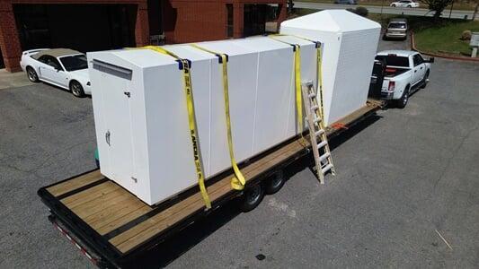 A large modular shelter loaded on an oversized trailer